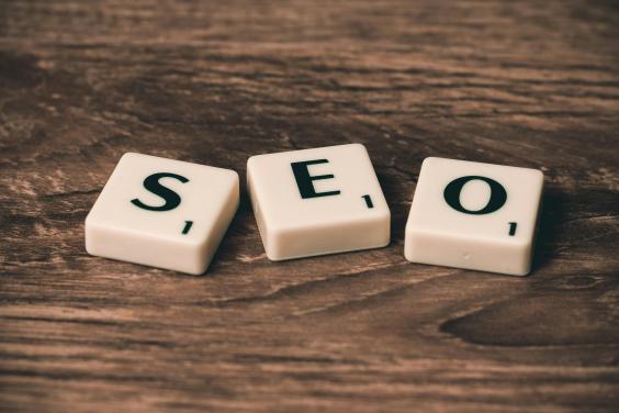 Letras de Scrabble que deletrean SEO sobre madera.